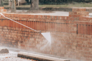 Soft-washing a brick retaining wall.